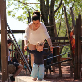 Erwischt auf dem Spielplatz: Übermama Sophie hilft Kind 2.0 beim Balancieren!